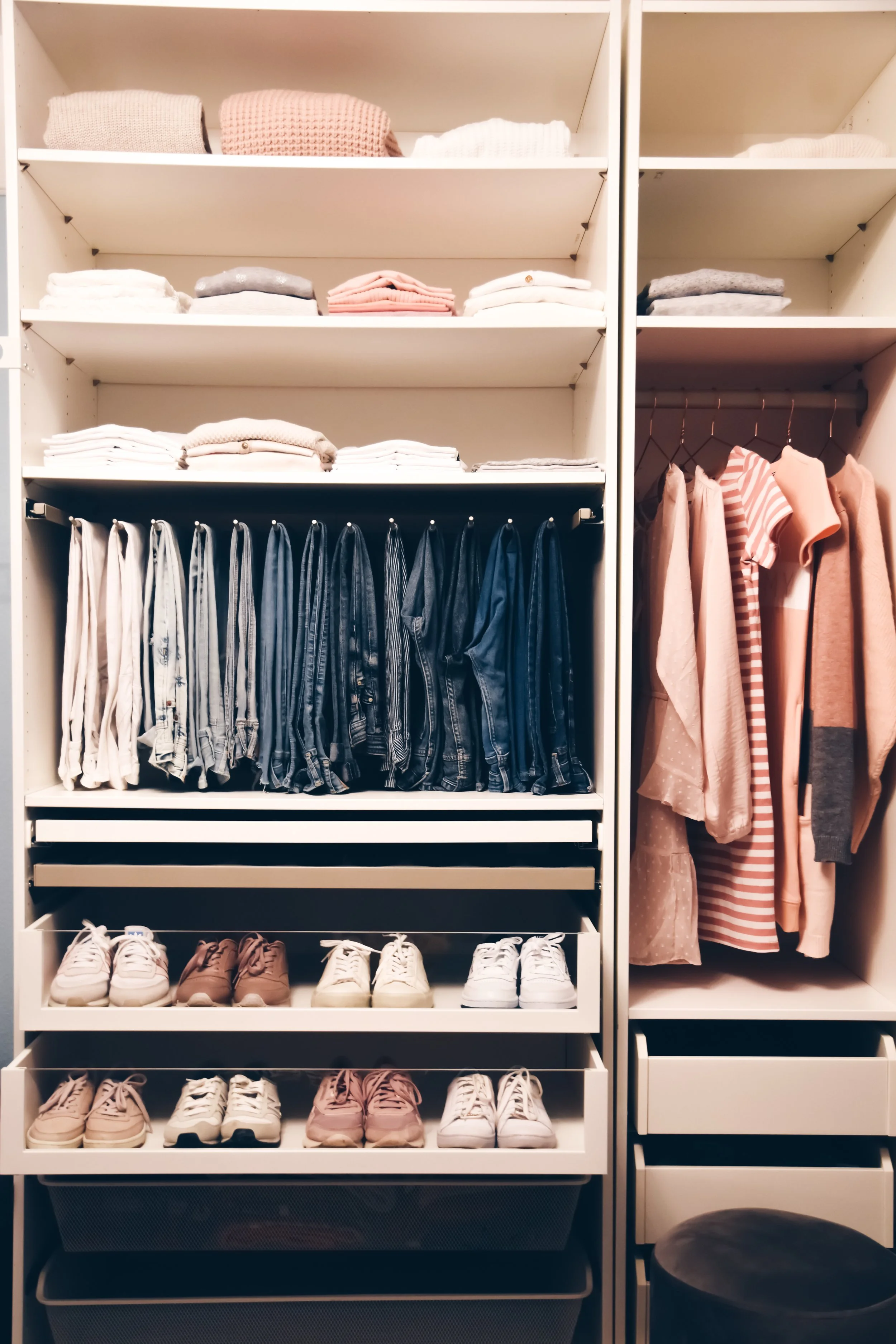 Closet organizer with folded clothes on top shelves, hanging denim jeans in the middle, and pairs of sneakers at the bottom, with a hanging section of pink and striped shirts on the right.