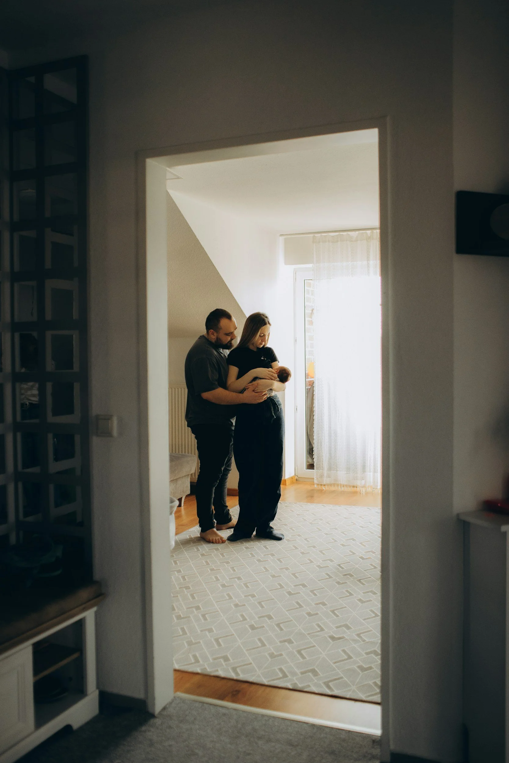 New parents holding newborn baby in nursery