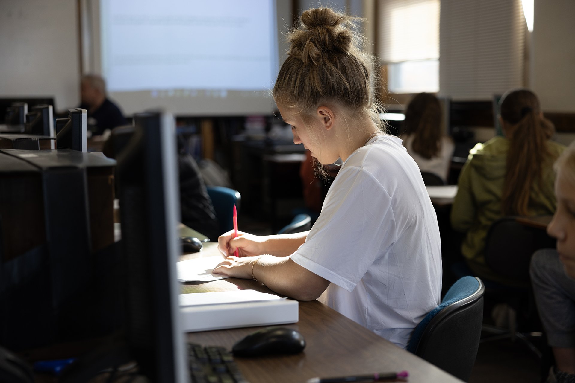 Girl writing in classroom 