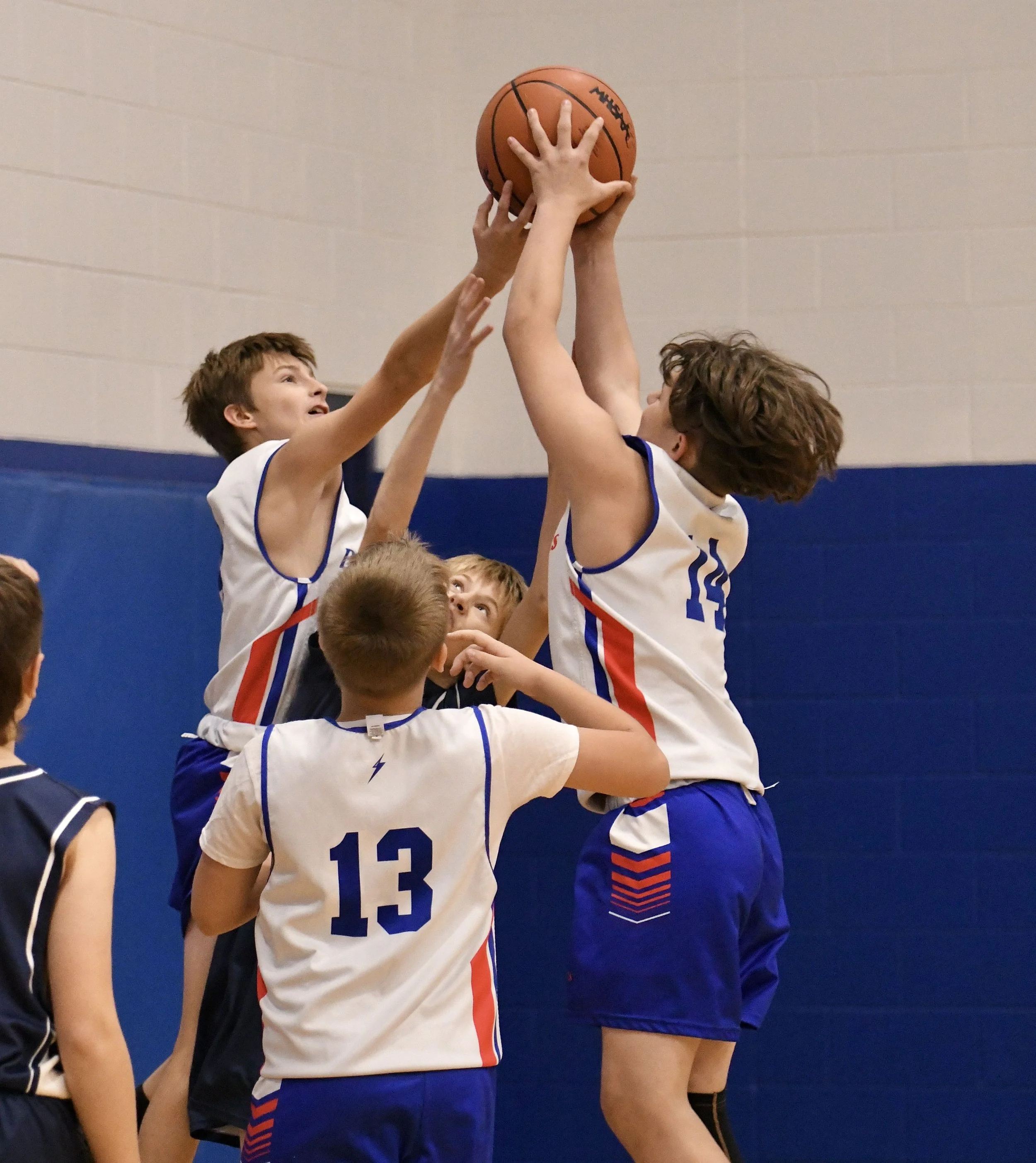 Two junior high Dollar Bay boys high above the crowd trying to secure a rebound.