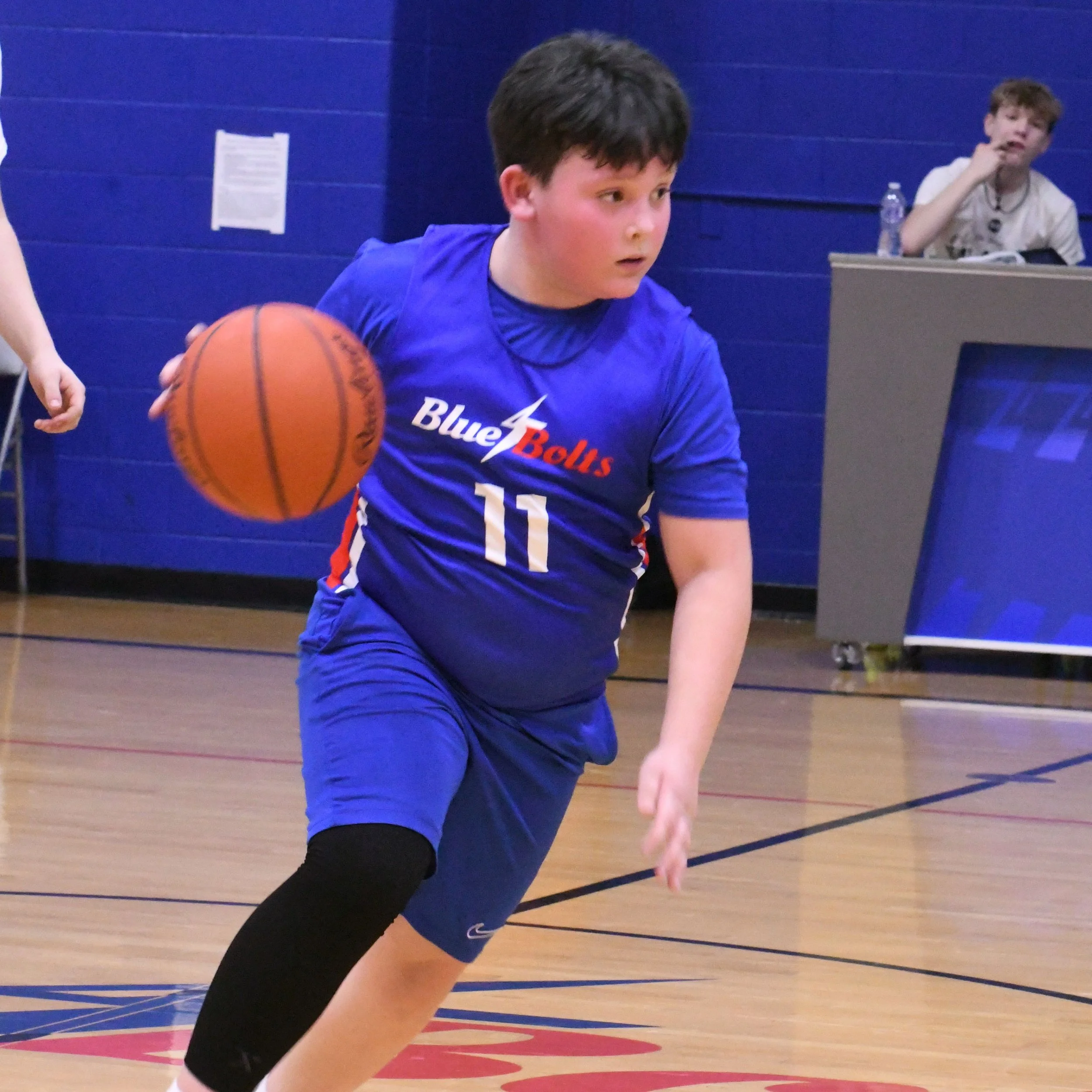Elementary boy dribbling a basketball.