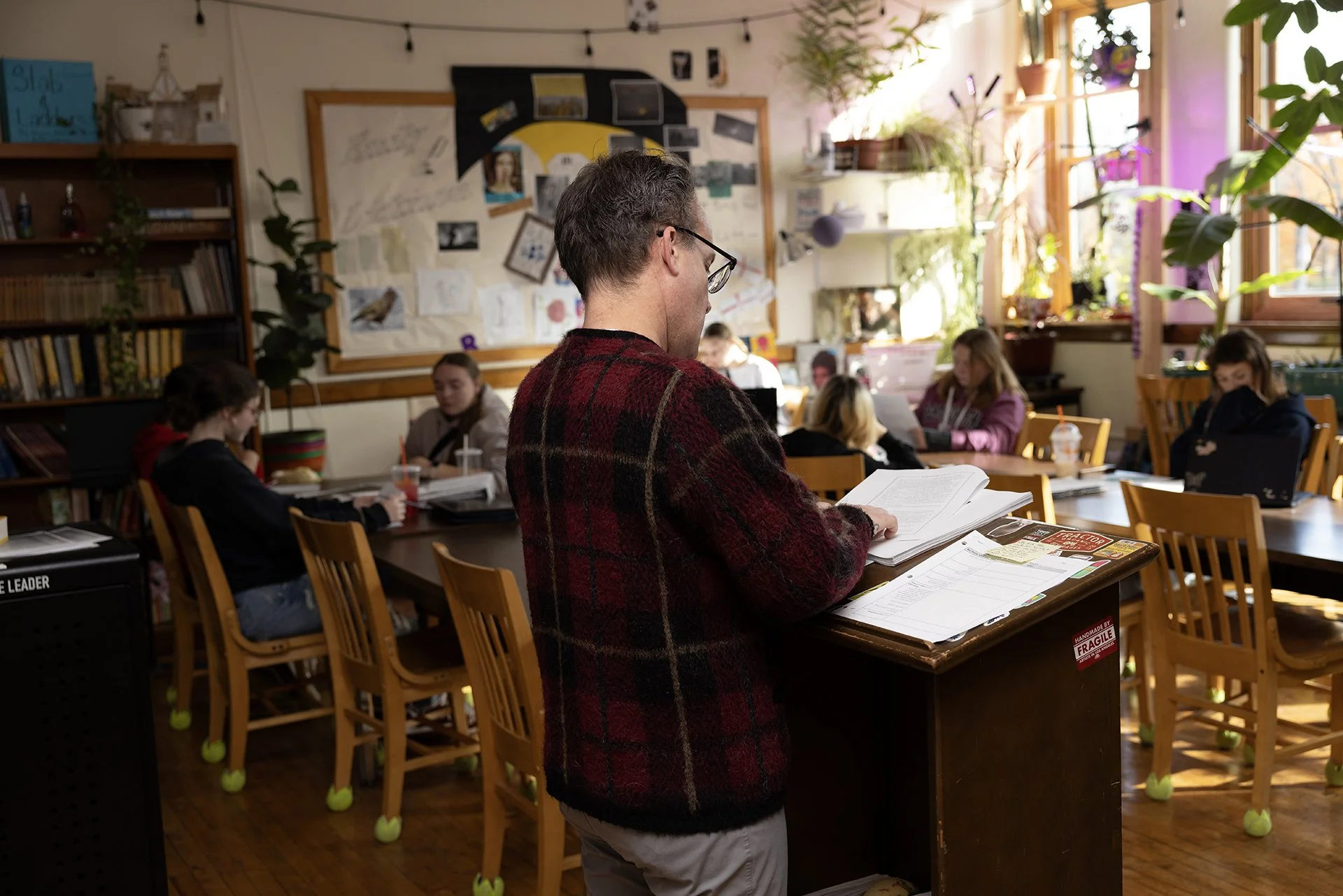 High school teacher behind a podium, delivering a lesson to the class.