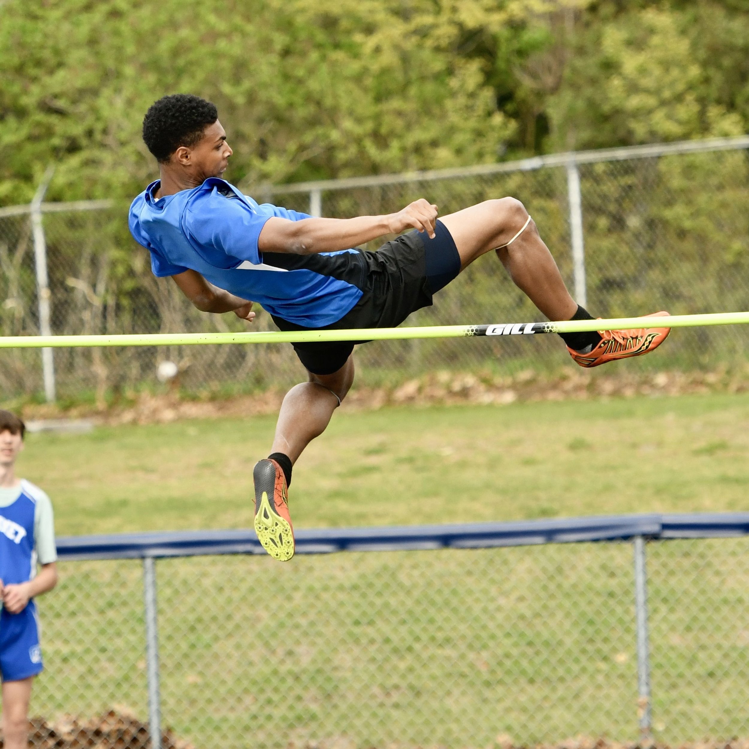 A high school high jumper about to clear the bar on a very high setting.