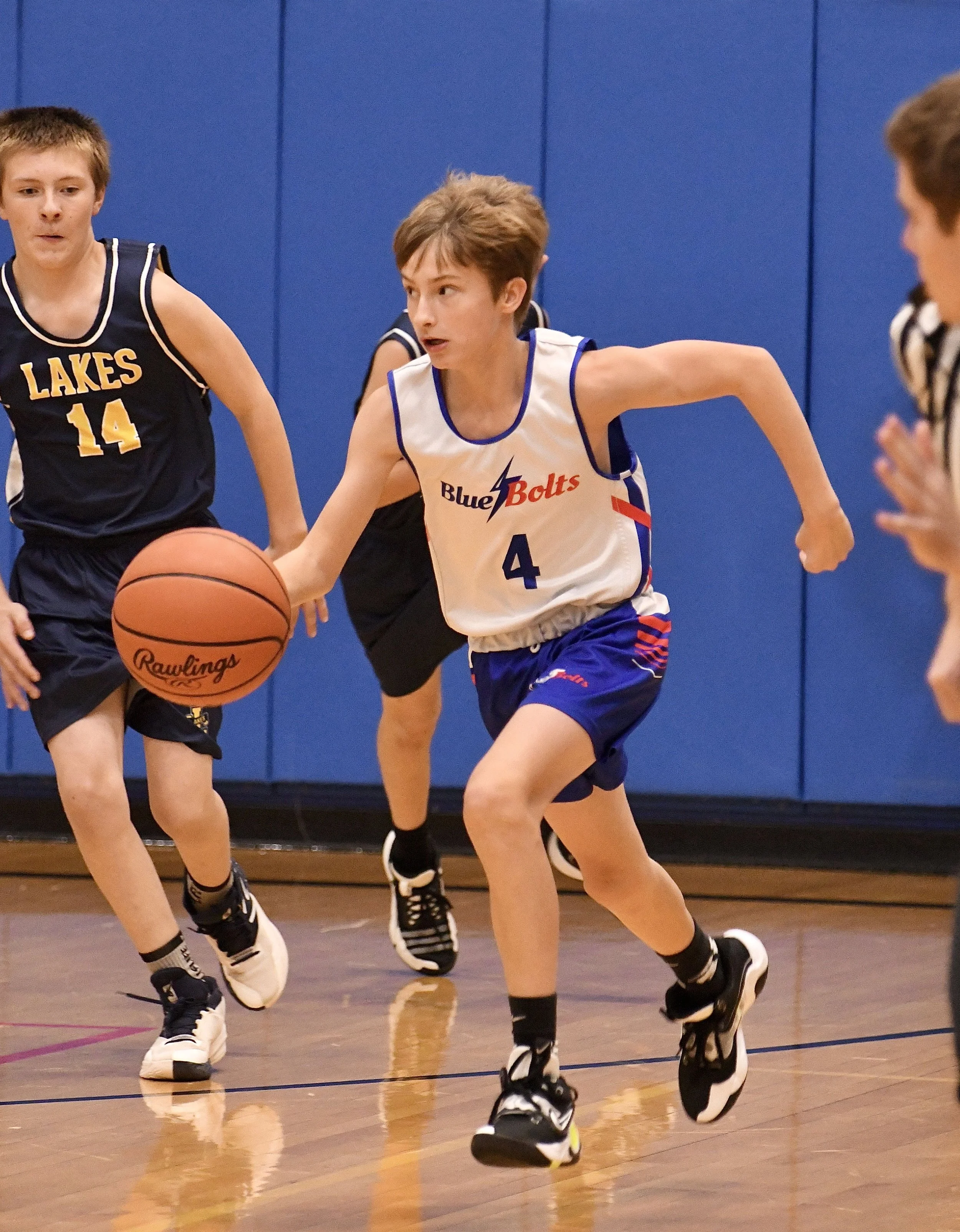 Junior high boy starting a fast break from deep in the backcourt.