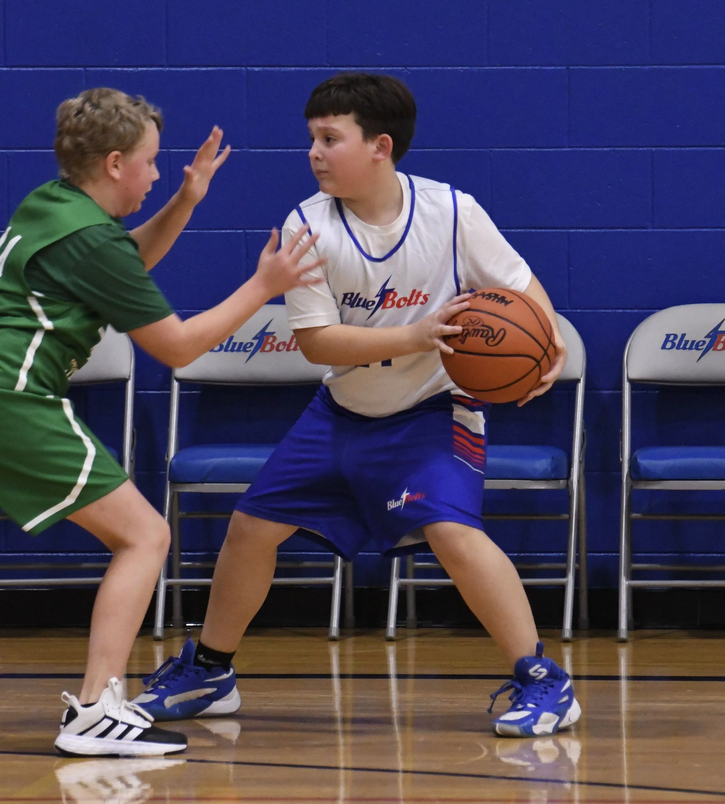 Junior high boy with the ball on his back hip, being defended by an opponent.