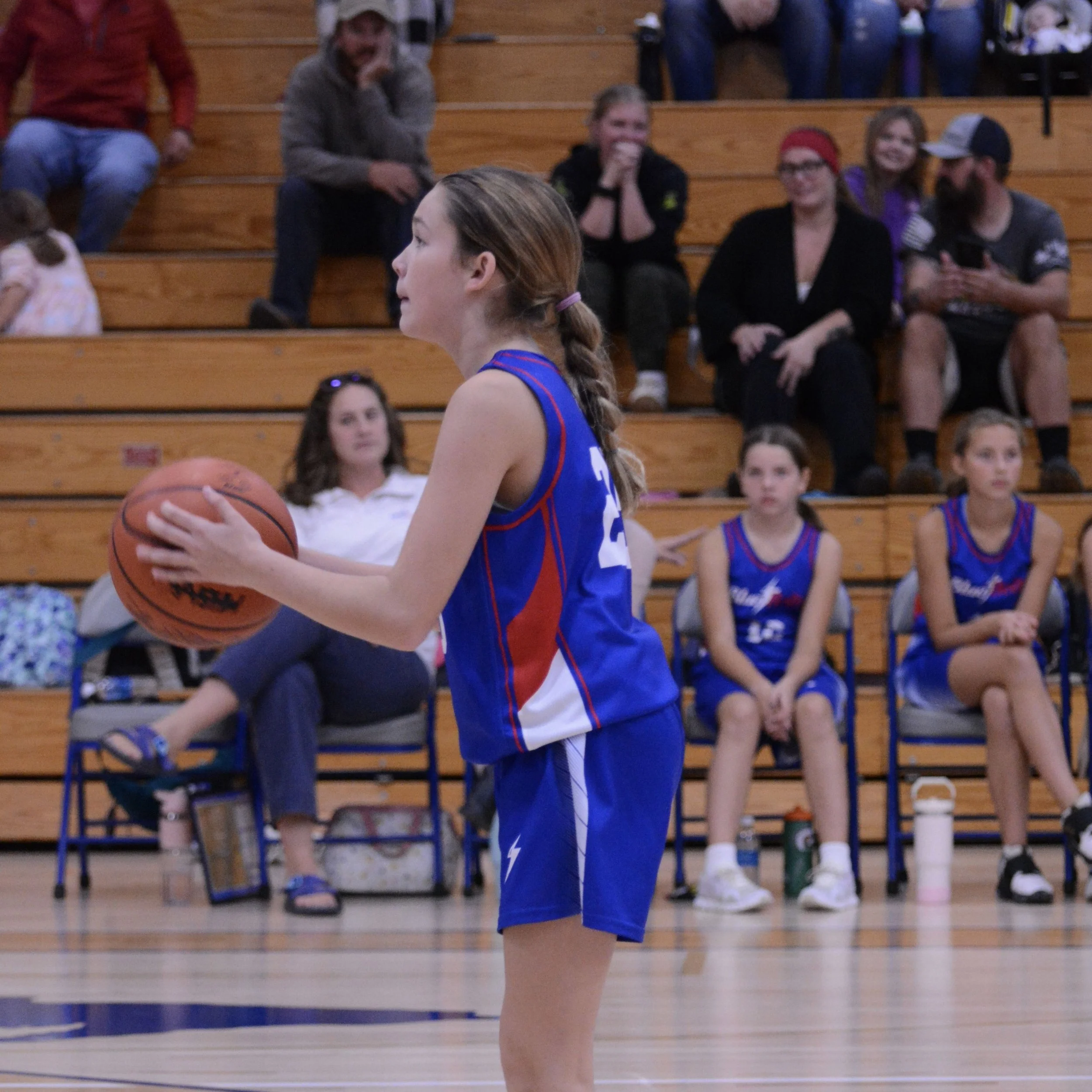 Junior high girl concentrating on shooting a fret-throw during the game.