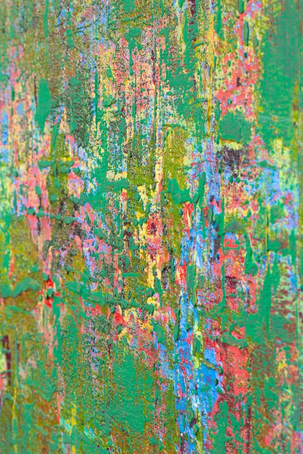Close-up of a textured, colorful abstract painting with layers of pink, yellow, green, blue, and black paint.