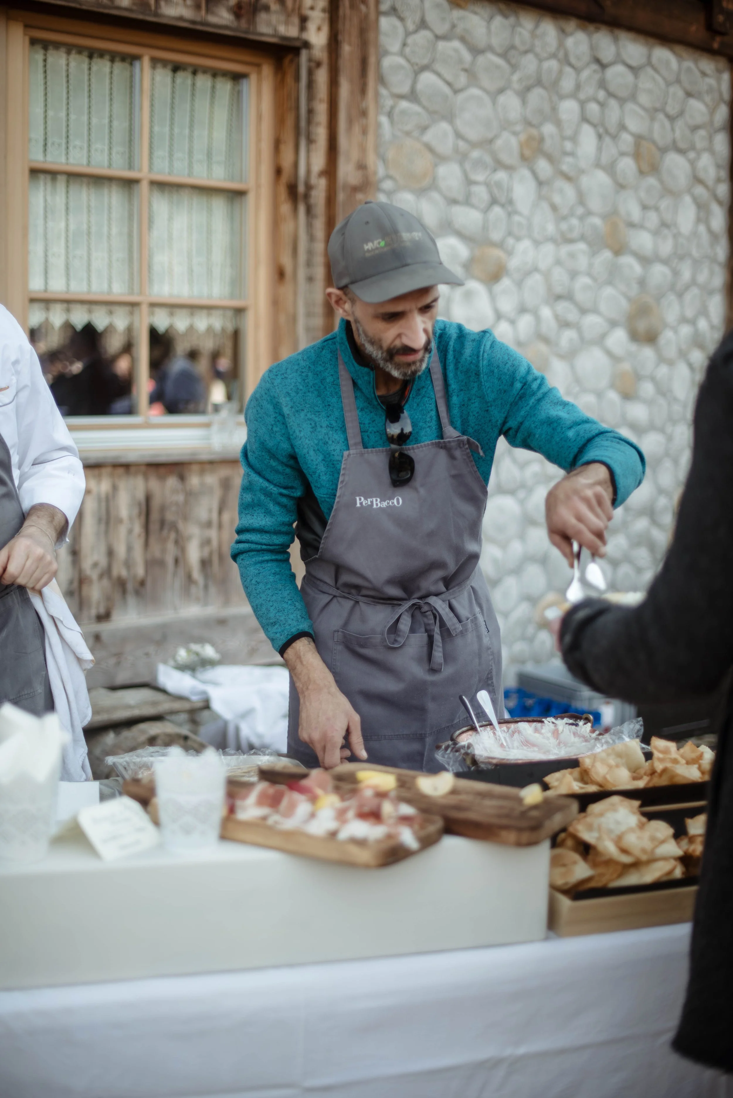Uomo che si serve del cibo da un buffet all'aperto in un ambiente rustico.