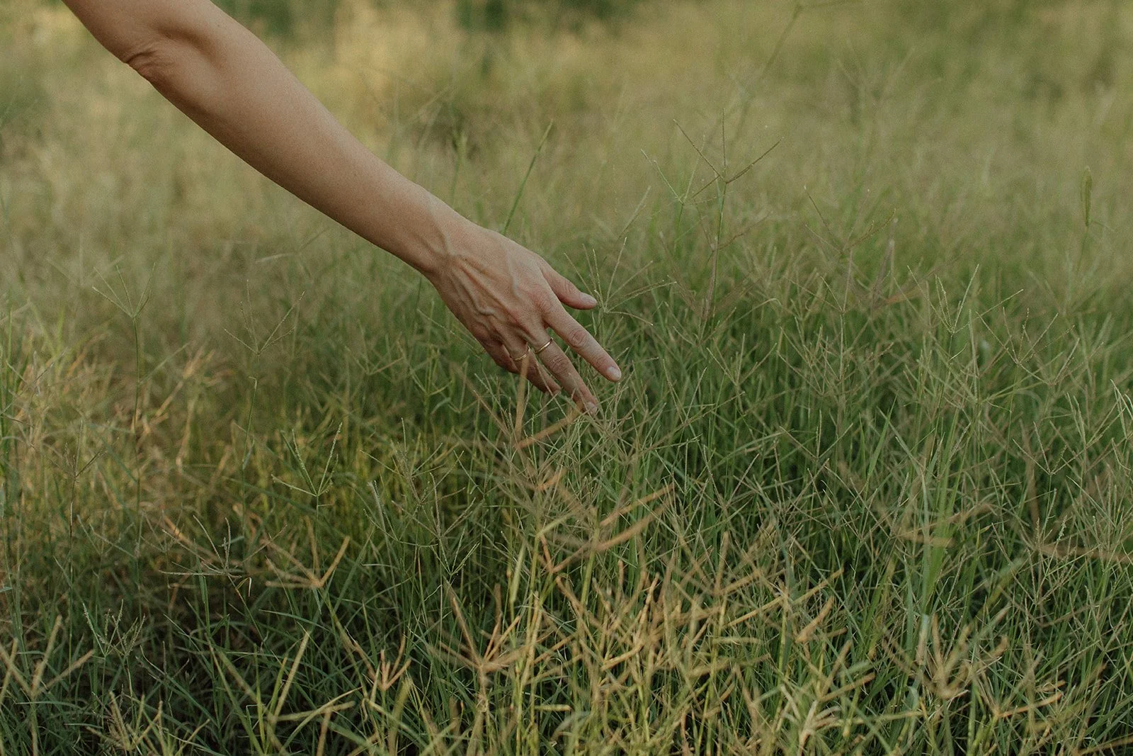 A mirror partially submerged in water reflecting gray and orange striped patterns, with a cracked concrete surface underneath and water ripples visible.