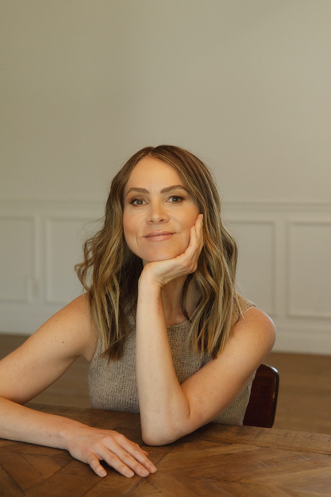 Woman with brown and blonde hair resting her chin in her hand. She is a therapist based in Arizona