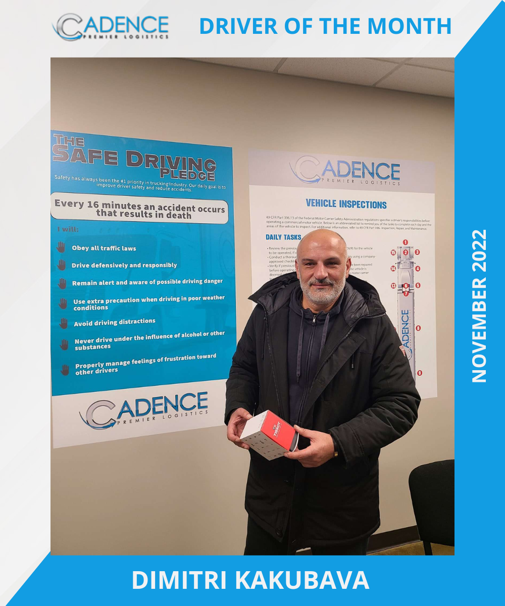 Man holding a box, labeled "Driver of the Month" by Cadence Premier Logistics, with safety pledge posters in the background, November 2022.
