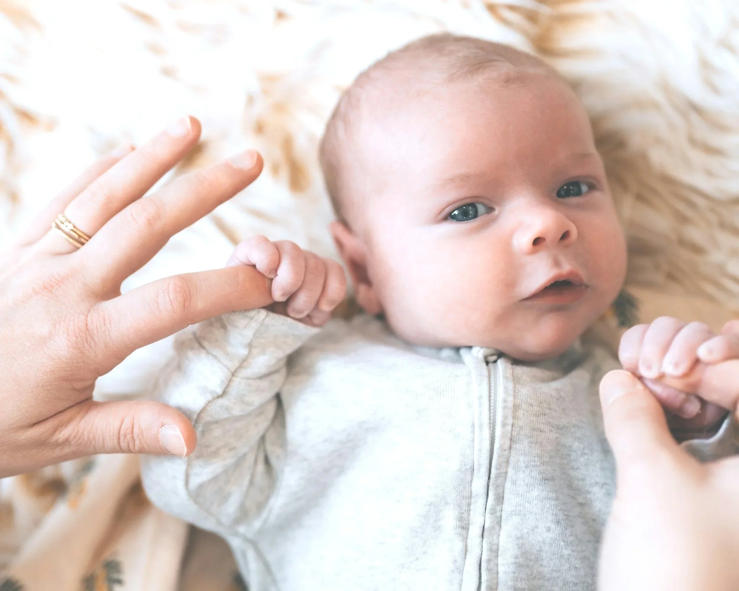 baby holding parent's finger