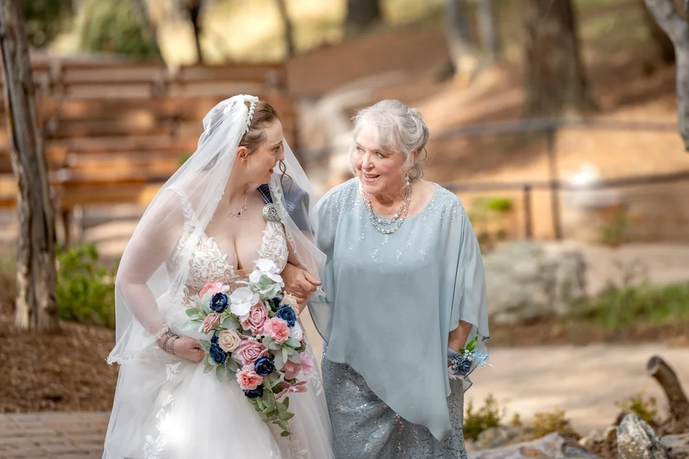 Bride walking arm in arm with her grandmother before an outdoor Colorado wedding ceremony