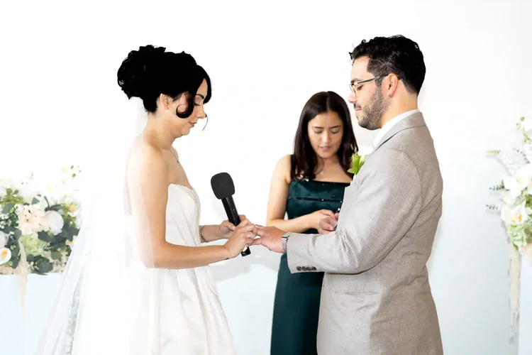 Bride placing a ring on the groom’s hand during their Longmont, Colorado wedding ceremony
