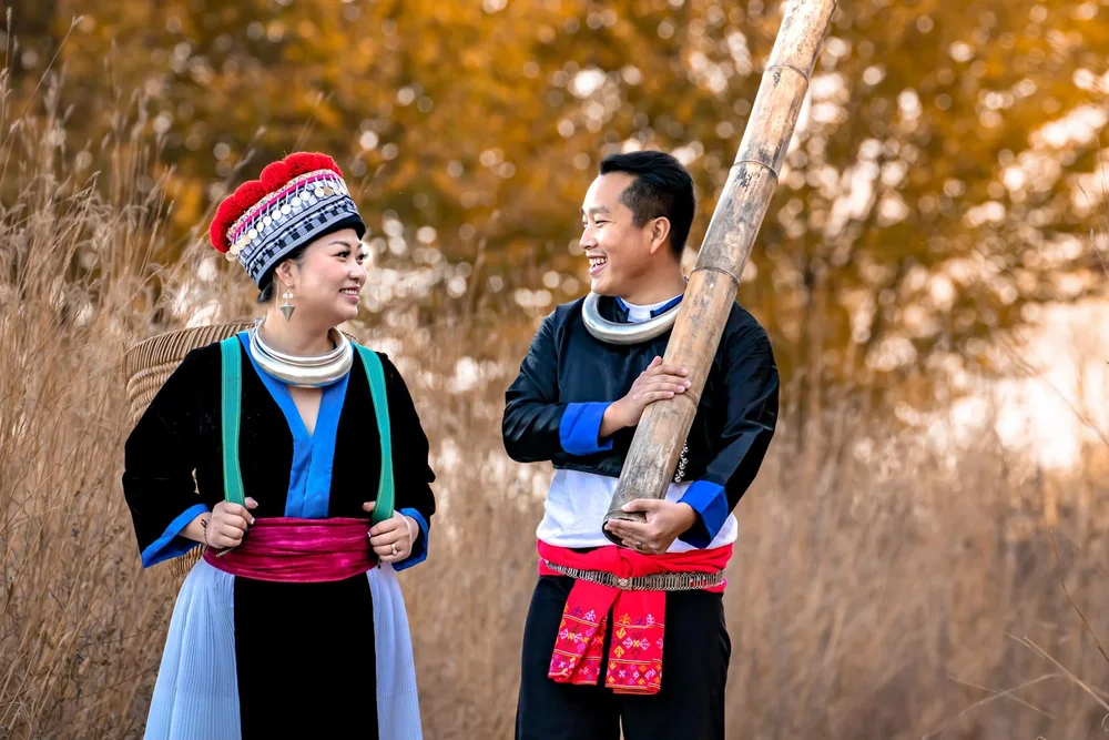 Smiling couple wearing traditional cultural clothing during an outdoor autumn portrait session