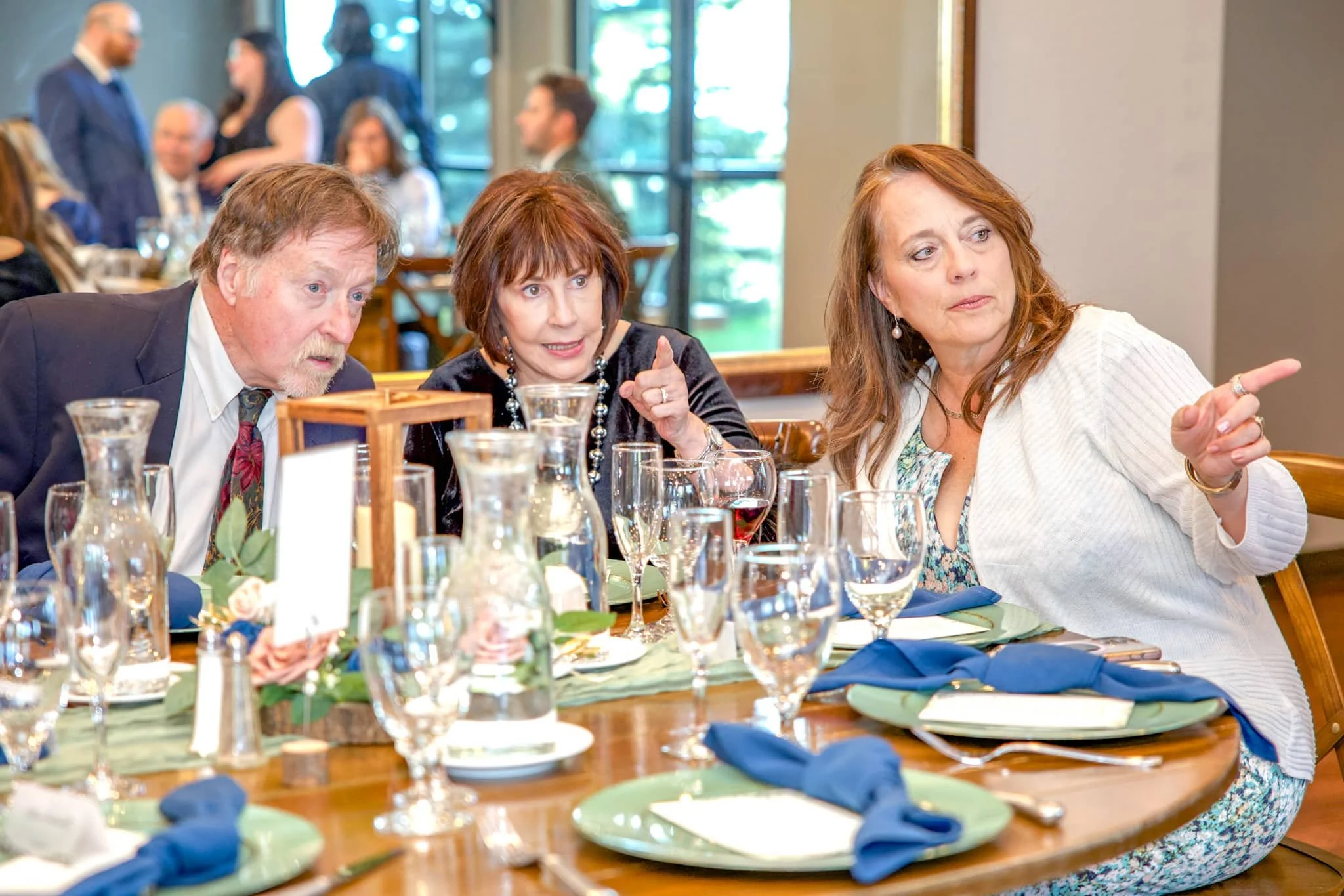 Guests sharing a conversation during a formal dinner event in Colorado, photographed by Grayson Flicks Photography.