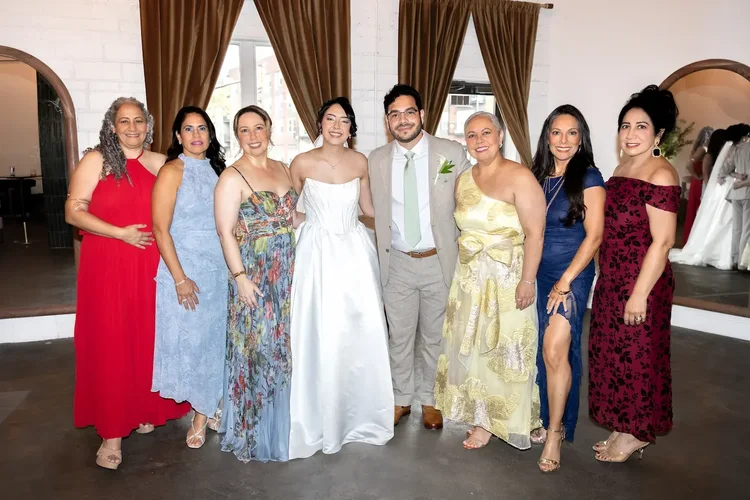 Bride and groom posing with women in colorful formal dresses at their Longmont, Colorado wedding