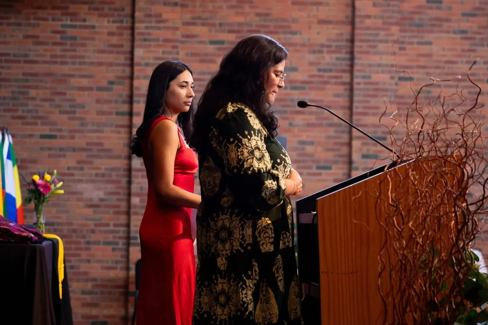 Speaker presenting at a podium during an indoor Colorado community event