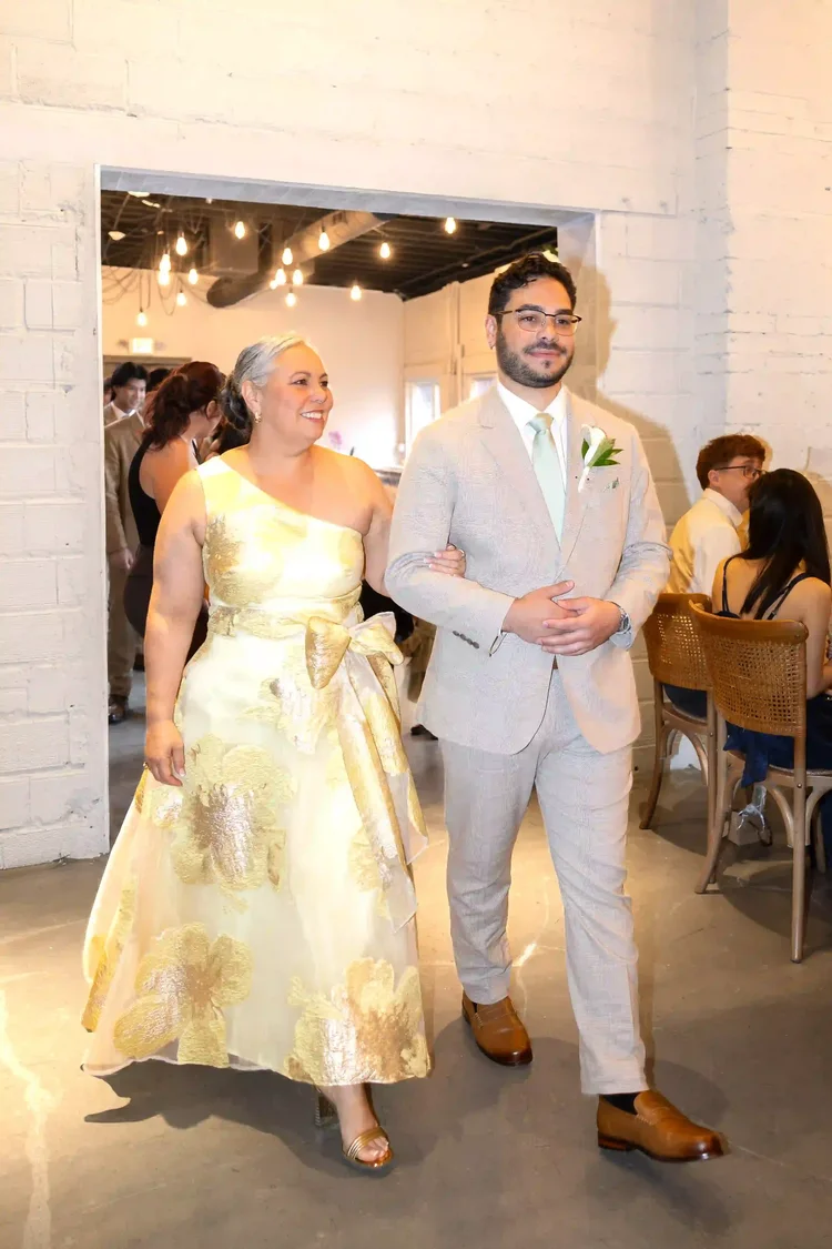 Groom entering the ceremony with a woman in a yellow floral dress in Longmont, Colorado
