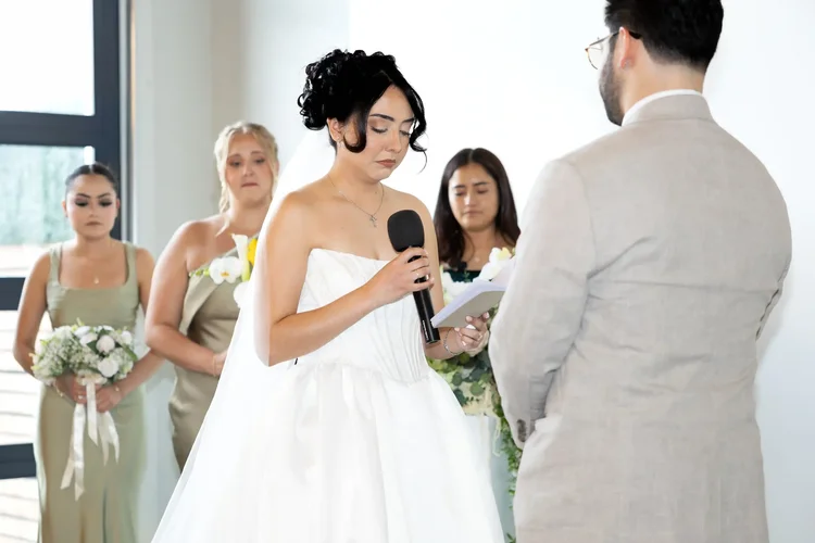 Bride reading her vows into a microphone at a Longmont, Colorado wedding ceremony