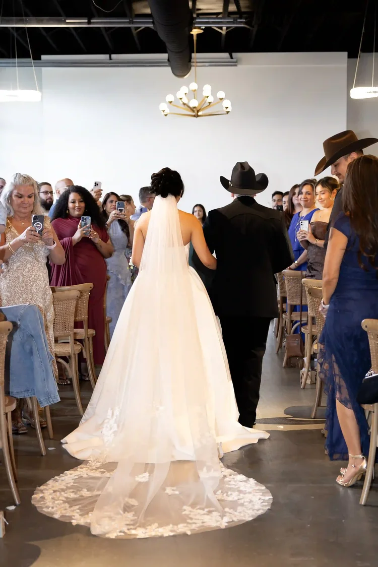 Bride walking down the aisle between standing wedding guests in Longmont, Colorado
