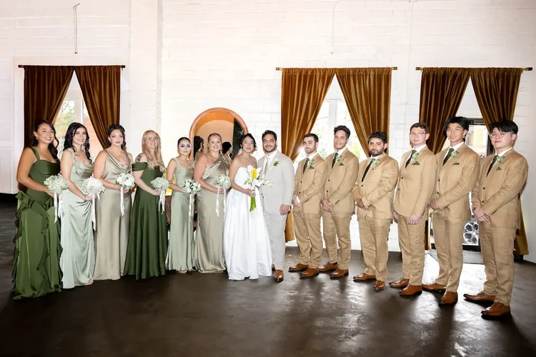 Bride and groom with their wedding party in green dresses and tan suits in Longmont, Colorado