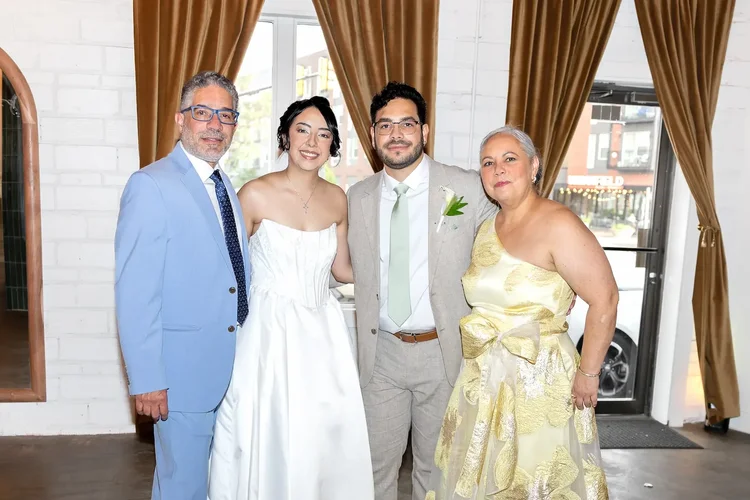 Bride and groom standing with a man in a blue suit and a woman in a yellow floral dress in Longmont