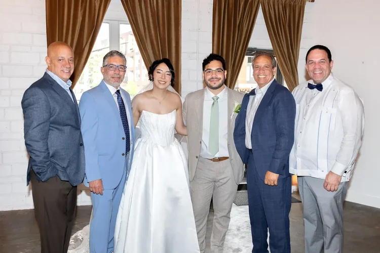 Bride and groom posing with four men in formal attire at their Longmont, Colorado wedding