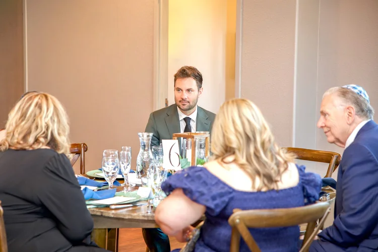 Guests engaged in conversation around a table during a formal Colorado event