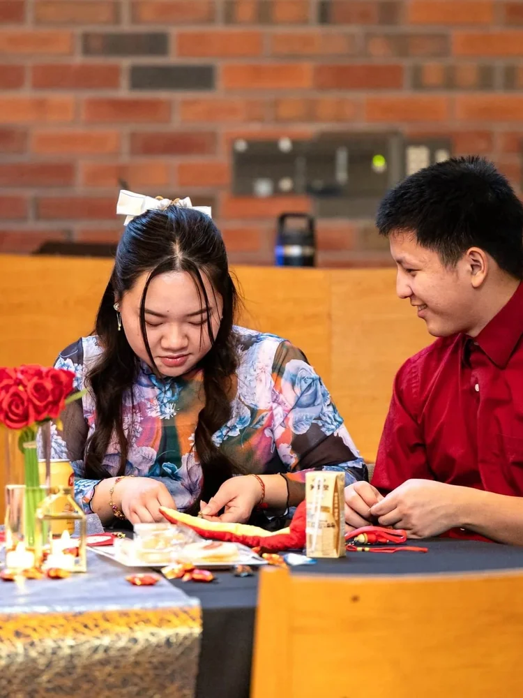Two participants joining an activity during an indoor community event in Colorado
