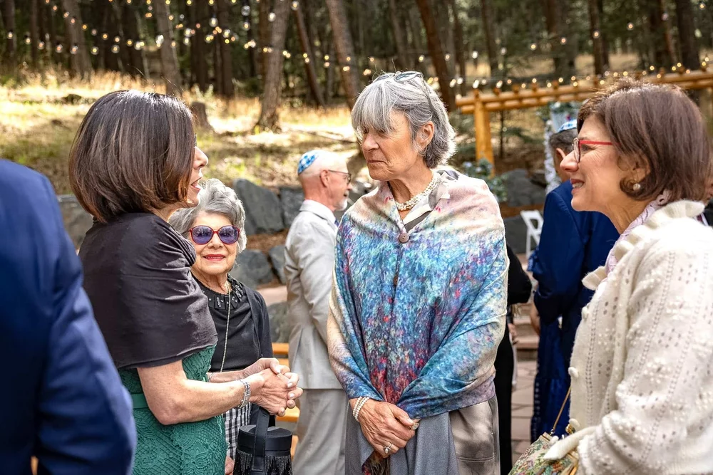 Guests sharing a candid conversation during an outdoor Colorado event