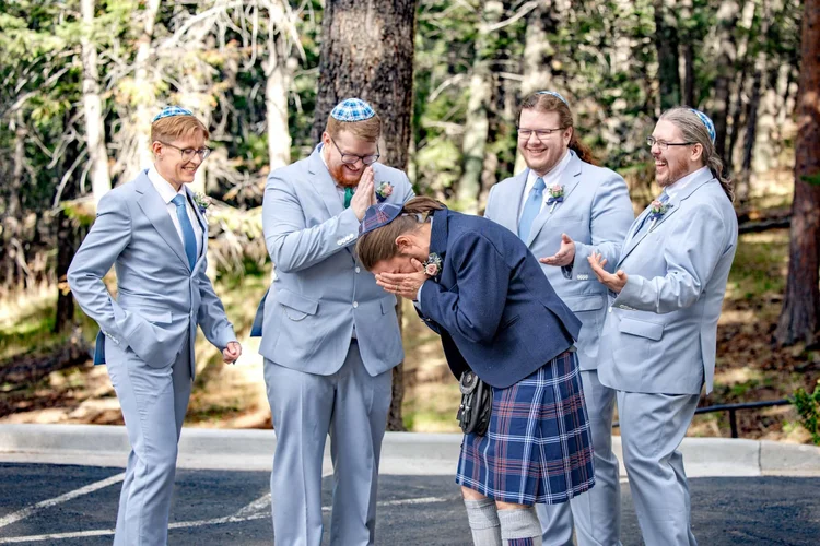 Groom laughing naturally with his groomsmen before an outdoor wedding ceremony in Colorado
