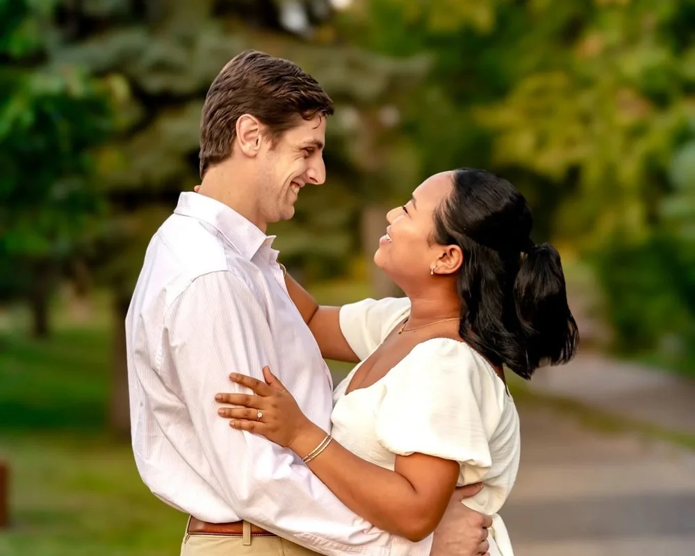 Couple laughing together during a relaxed outdoor portrait session with natural light