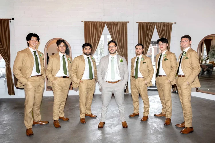 Groom in a light gray suit standing with groomsmen in tan suits and green ties in Longmont, Colorado