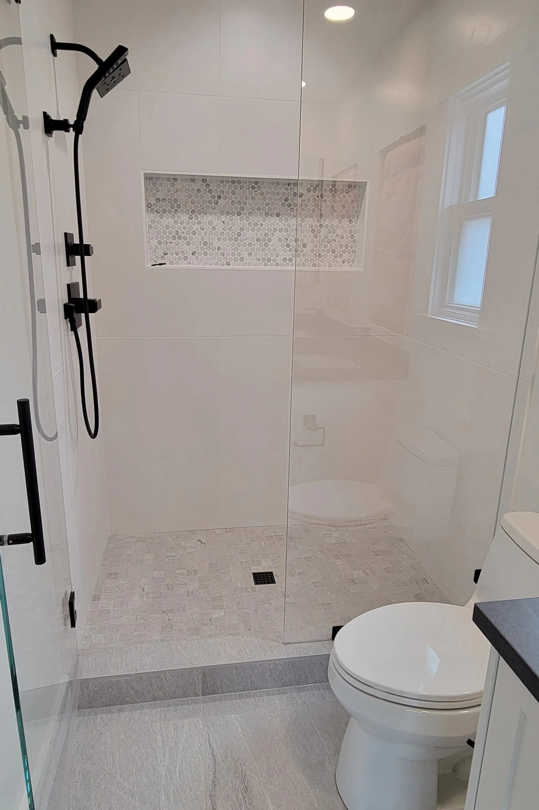 5' walk-in shower with 12x16 tiles. Includes shampoo niche. Oil rubbed bronze finishes. 