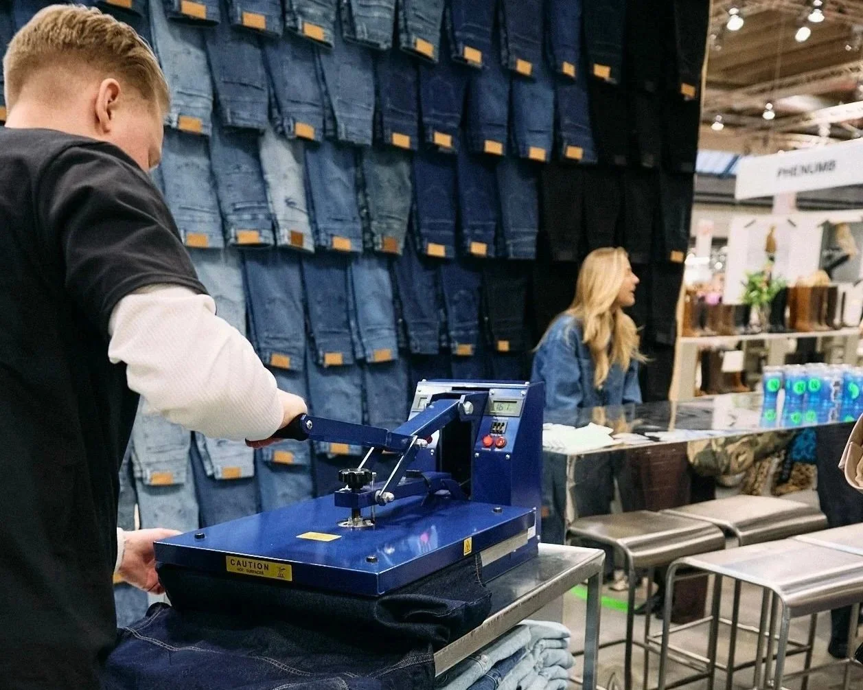 Person applying heat transfer vinyl to a black T-shirt using a heat press machine.