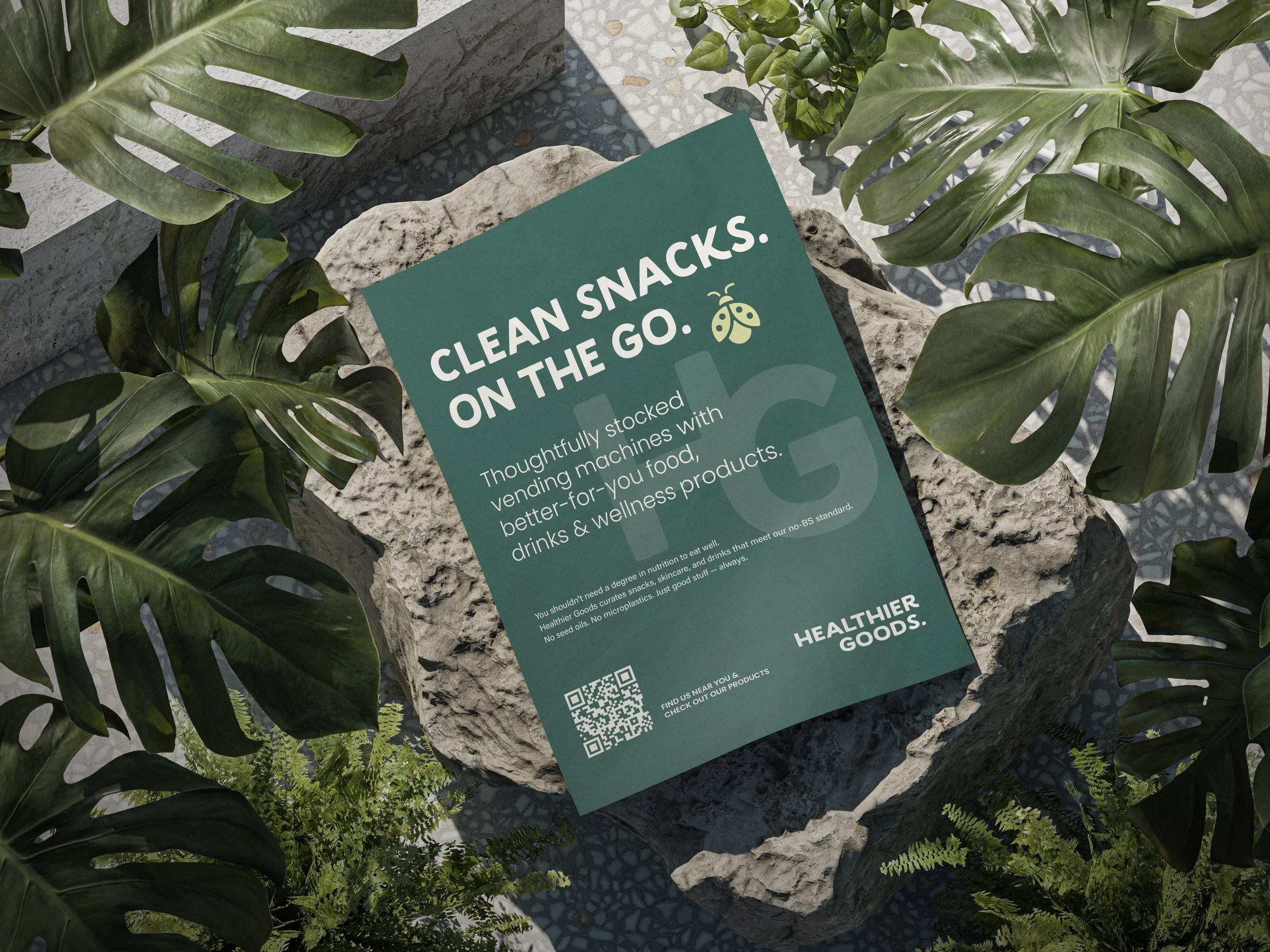 A clothing or signboard promoting healthy snacks on the go, placed on a stone surrounded by green leafy plants.