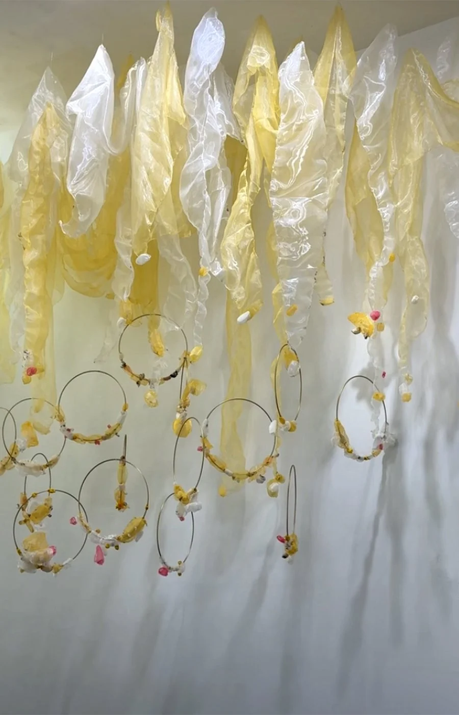 INTO THE QUIET
A contemporary textile installation of vibrant, flame-scorched fabric forms suspended within structural hoops. This piece interacts dynamically with light and movement, creating an oasis of calm within the space. Click to view full pro