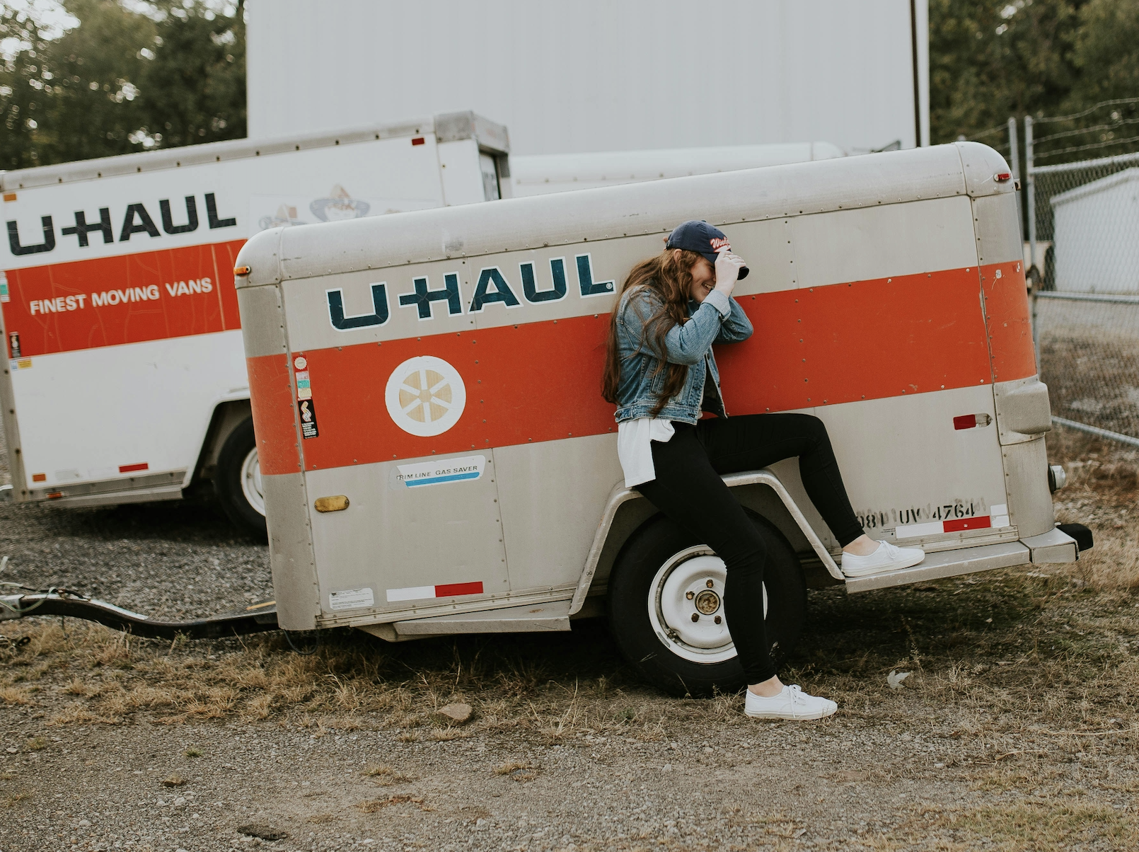 Person sitting beside a U-Haul trailer during a stressful move, representing the housing challenges pastors can face after an unexpected ministry transition.