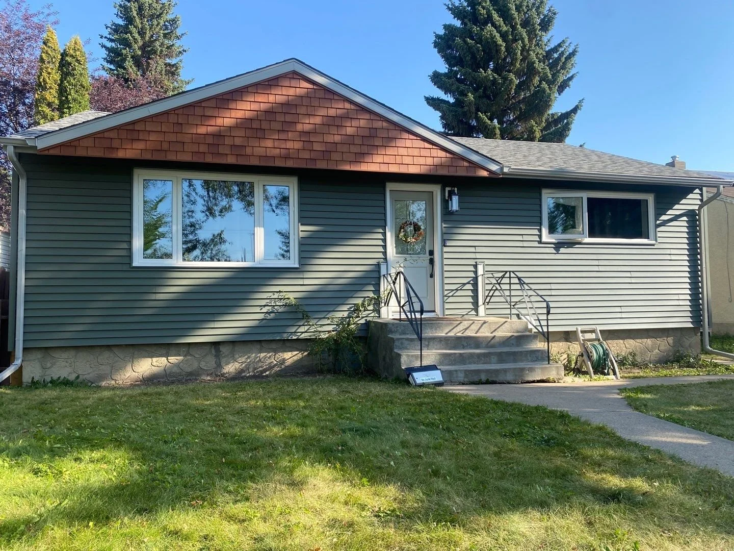 This photo shows a bungalow in Edmonton with Mitten vinyl siding and Tando vinyl shakes.