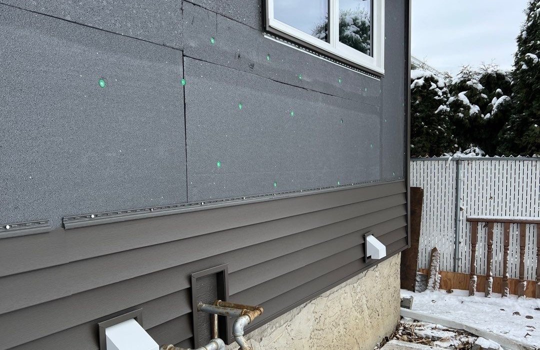 Vinyl siding installed over exterior insulation on a renovation project in Leduc AB.