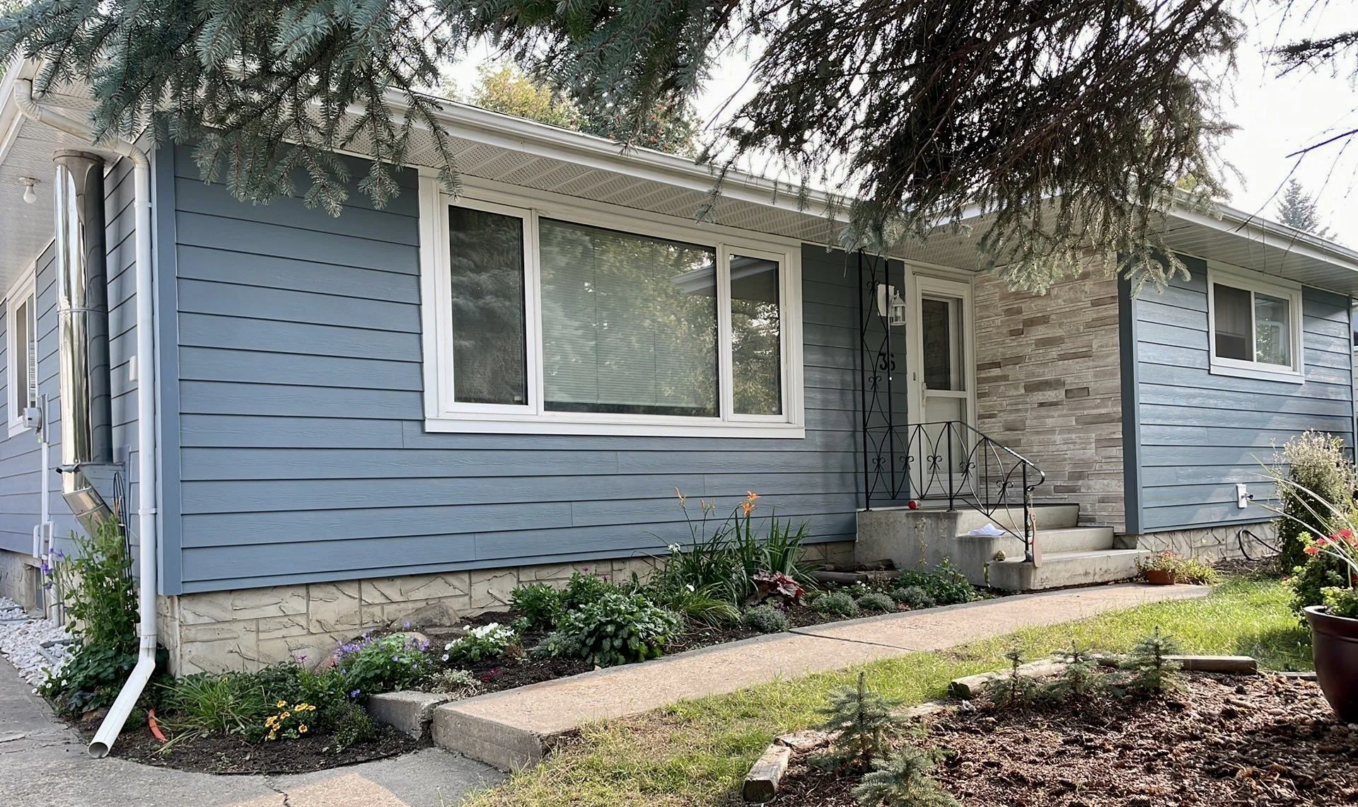 Boothbay Blue Hardie Plank and Versetta Stone installed on an Edmonton home