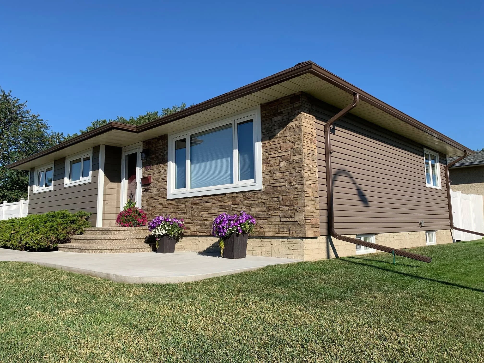 A completed siding renovation with Versetta Stone accent on an Edmonton home