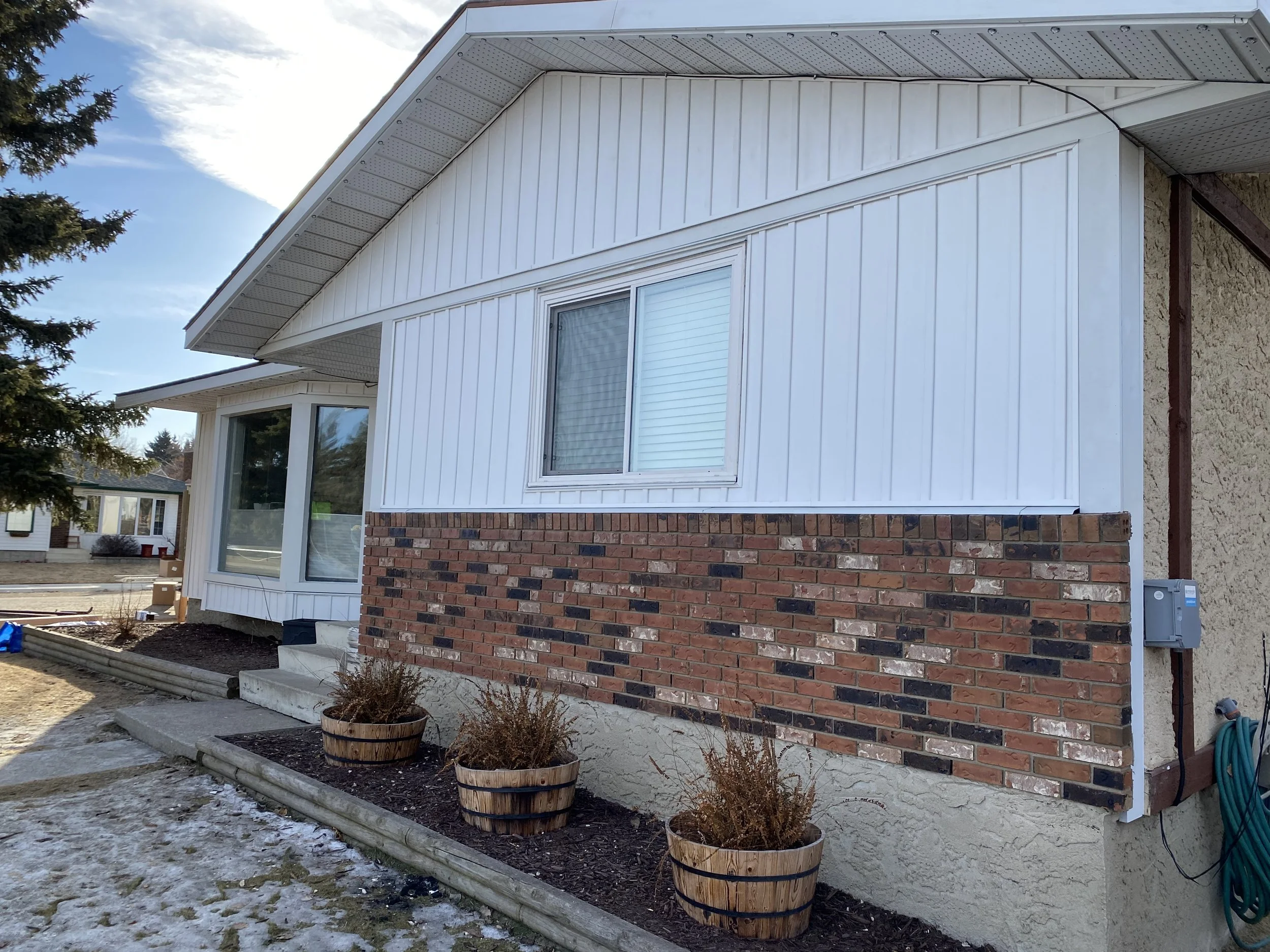 Vinyl board and batten with red and brown brick.jpg