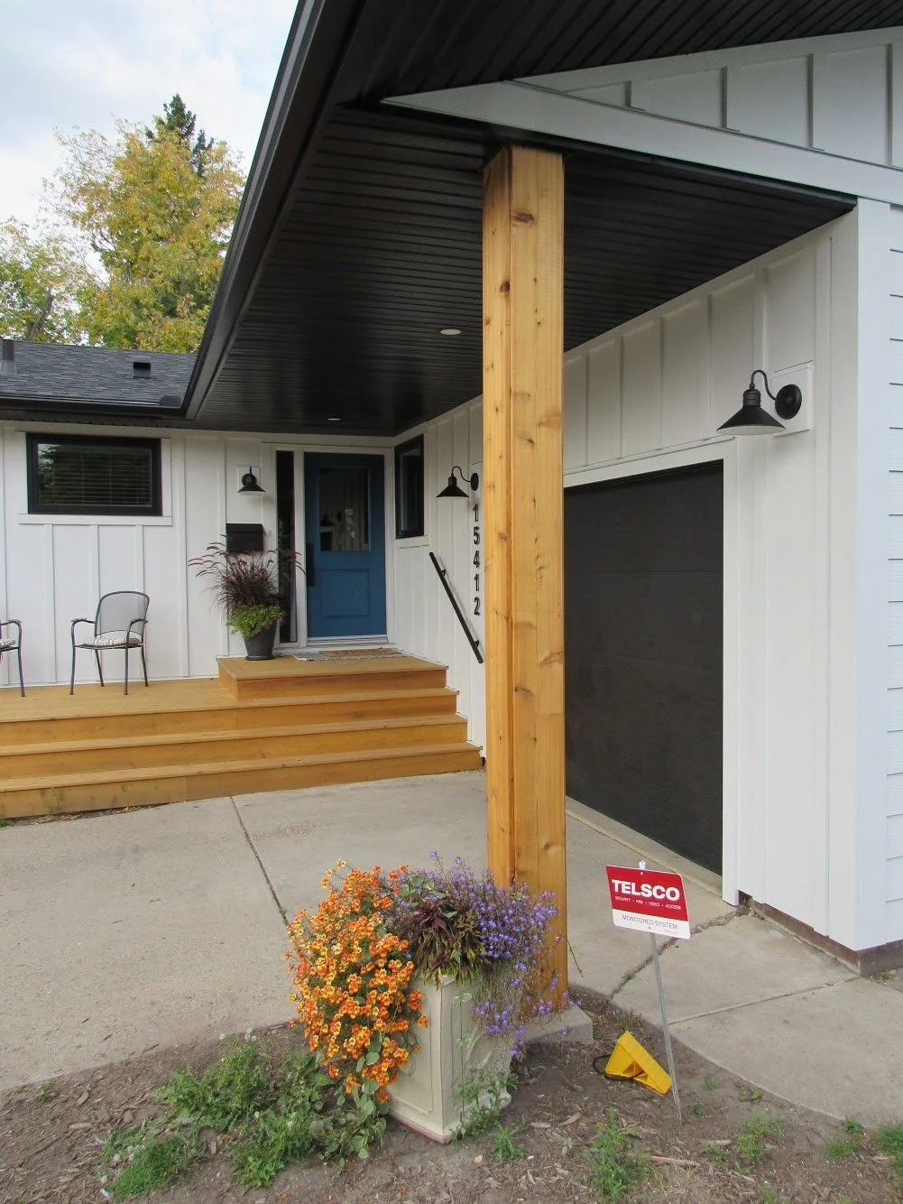 This bungalow in Edmonton includes  black aluminum soffit, fascia, and eavestrough along with white Hardie board siding.