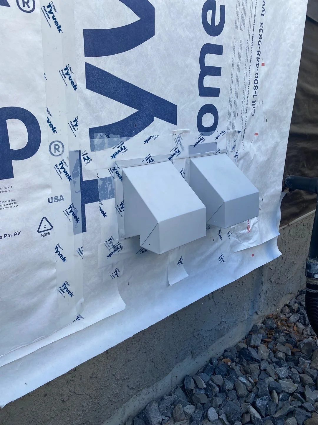 This photo shows an example of new steel vent covers before the siding installation.