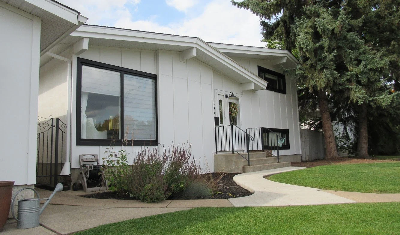 This front facade siding renovation uses HardiePanel board & batten in Arctic White.