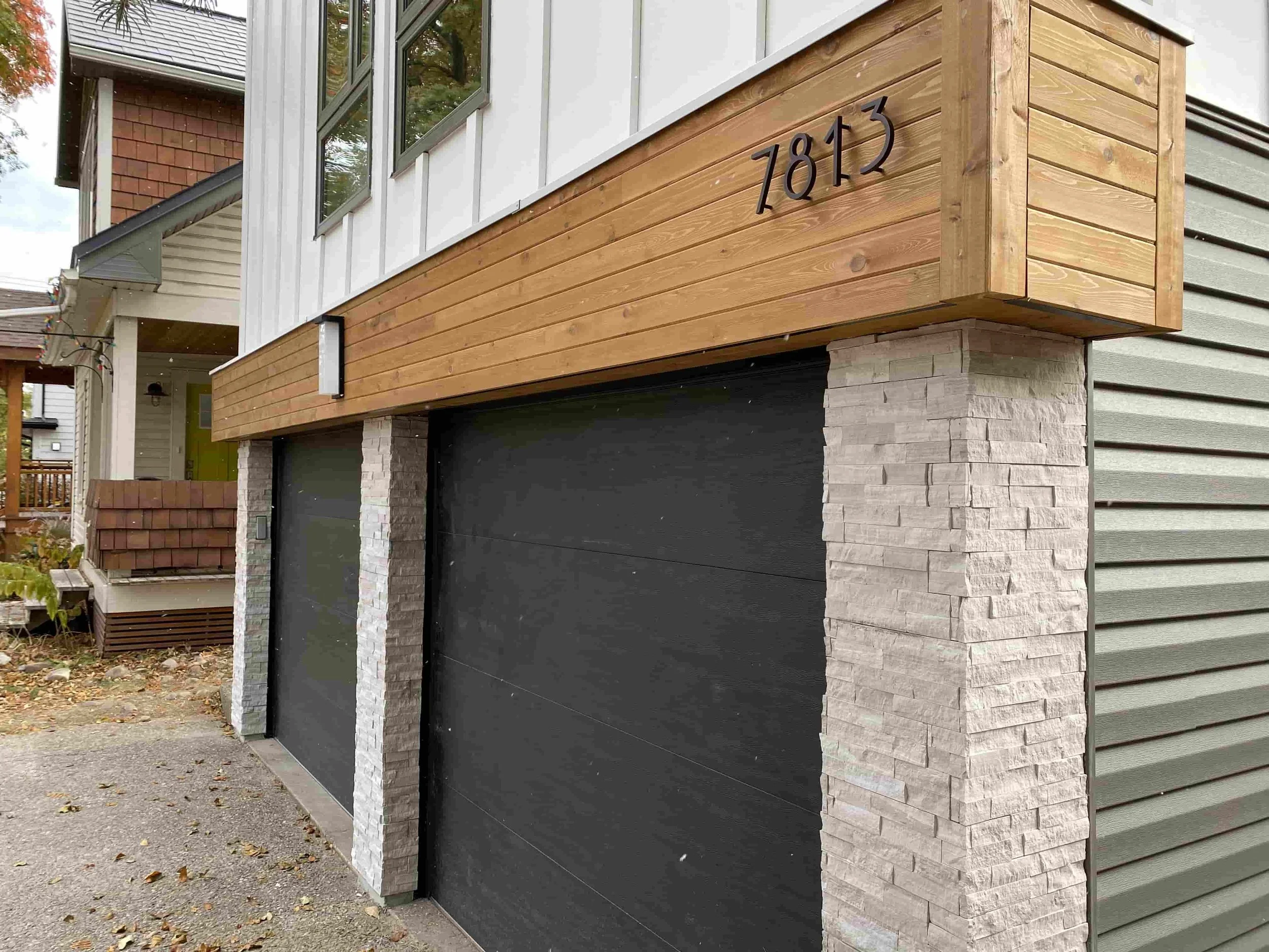 Modern exterior siding renovation with Hardie Panel board & batten and cedar siding accent.