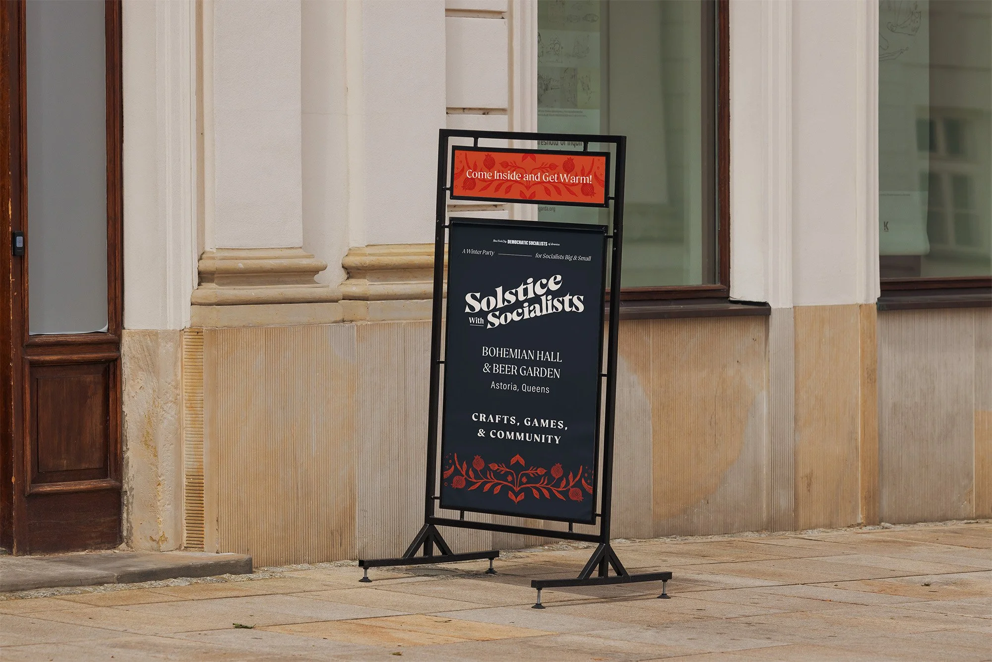 Mockup of an a-frame sign inviting people inside to come and get warm at the solstice with socialists community event featuring folk illustration and bold orange and navy blue block colors