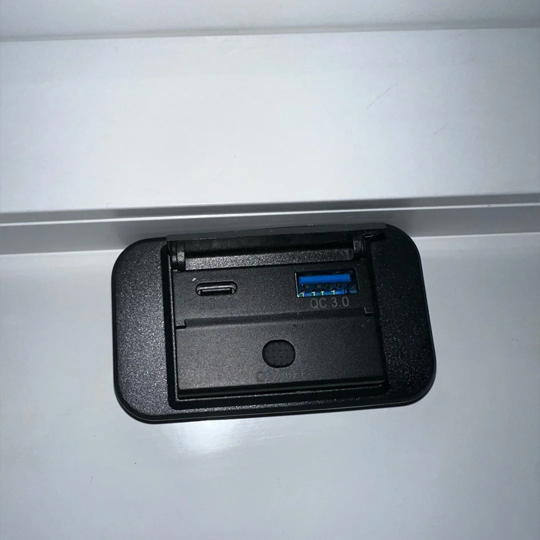 Close-up of a power outlet with a USB-C port and a blue USB 3.0 port on a white surface.